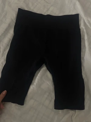 Svarta cykelshorts/gym leggings - Svarta, tighta cykelshorts/gym i stretchigt material med hög midja. Perfekta för en sportig look eller att styla med oversized t-shirt. Mjuka och bekväma, utan synliga loggor eller detaljer.