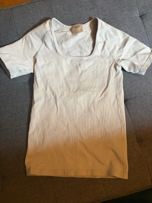 Ljusblå ribbad topp från AIMN - En ljusblå ribbad topp från AIMN med korta ärmar och fyrkantig ringning. Toppen har en slim passform och diskreta ränder i materialet. Perfekt att styla med jeans eller kjol.