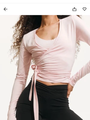 Ljusrosa omlottopp med knyt - Rosa pilates omlott topp från hm. Storlek M, men passar S-L skulle jag säga. Supermjukt material! Använd 1 gång. Helt slutsåld. 