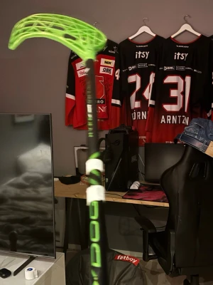 Grön innebandyklubba Oxdog - Säljer en innebandyklubba från Oxdog med svart skaft och grönt blad. Klubban har vita detaljer och grepptejp. Perfekt för dig som gillar innebandy och vill ha en snygg och lätt klubba med cool design.