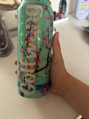 Golfwang x Arizona burk - Säljer en mintgrön Arizona burk i samarbete med Golfwang. Burken har ett snyggt körsbärsblom-motiv i rosa och svart samt stor Golfwang-logga i vitt och gult. Perfekt som samlarobjekt eller dekoration.