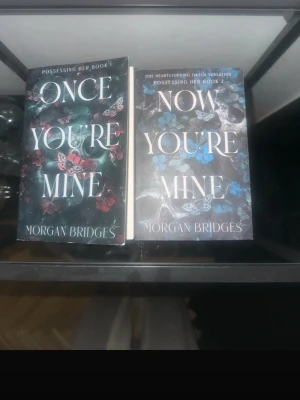 Once You're Mine & Now You're Mine - Två böcker av Morgan Bridges: 'Once You're Mine' och 'Now You're Mine'. Omslagen är svarta med fjärilar i rött och blått, och stora vita titlar. Perfekt för dig som gillar spännande och romantisk skönlitteratur på engelska.