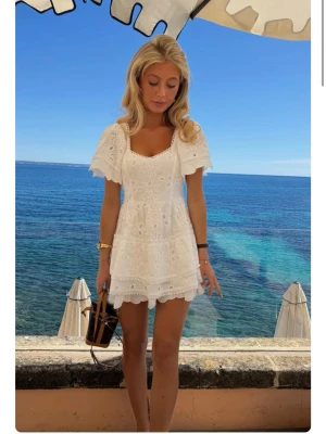 Vit broderad kortklänning med volang - Superfin vit kortklänning med broderade detaljer och volangkant. Klänningen har korta ärmar och en söt v-ringad halsringning. Helt oanvänd med lappar kvar!!! Perfekt till student/ midsommar/ sommar osv! Lånade bilder från hemsidan. 