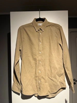 Beige manchesterskjorta från Samsøe Samsøe - Säljer en beige långärmad skjorta från Samsøe Samsøe i mjuk manchester. Skjortan har klassisk krage, knappar framtill och en avslappnad passform. Perfekt för dig som gillar stilrena och tidlösa plagg. Jag kan gå ner i pris.
