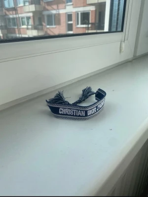 Navy blue armband  - Snyggt blått tygarmband. Armbandet har tofsar i ändarna och justerbar knytning. Perfekt accessoar för att lyfta din outfit med en exklusiv touch.