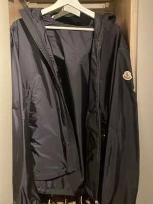 Moncler Grimperus Windbreaker Marinblå - Säljer min snygga Moncler Grimperus windbreaker i färgen marinblå. Jackan är perfekt för lite varmare väder och är bra till hands när det blåser eller regnar. Jackan är köpt i Moncler butiken i Stockholm och kvitto, tags etc kommer med på köpet. Ifall du har några frågor eller funderingar tveka inte att höra av dig! (KVITTO FINNS)