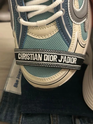 DlOR justerbart armband - vit/mörkblå - Riktigt snyggt och somrigt armband som passar alla. Passar till olika outfits men går även att justera så de passar just dig perfekt. En riktigt bra investering som kommer göra det lilla extra för din outfit för ett billigt pris! 