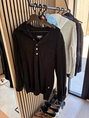 Svart frotté tröja från nikben  - Svart skjorta från Nikben i frotté med lång ärm, bröstficka och knappar framtill. Perfekt för en avslappnad och trendig look.
