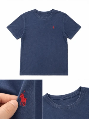 Marinblå t-shirt från Polo Ralph Lauren - Klassisk marinblå t-shirt från Polo Ralph Lauren med röd broderad logga på bröstet. T-shirten har rund halsringning och korta ärmar. Tillverkad i mjuk bomull för en skön känsla och enkel stil. Den har förlorat lite färg.