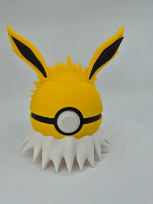 Pokémon Jolteon  - Snygg pokeball inspirerad av Jolteon från Pokémon. Bollen är gul med svarta detaljer, vita taggar runt botten och stora spetsiga öron. Tillverkad i plast och öppnas med en knapp. Perfekt för småprylar, smycken eller som samlarpryl.