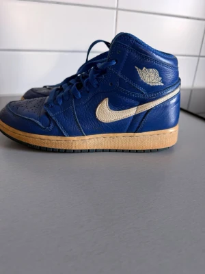 Blåa Nike Air Jordan 1 High sneakers - Kan gå ner i pris vid snabb affär☁️☁️☁️☁️☁️☁️☁️☁️Säljer ett par blåa Nike Air Jordan 1 High sneakers köpta på Footlocker för några år sedan. Väl använda men har inga hål eller defekter förutom det som syns på bilden: gulnat lite vid sulan längst ner och har lite veck. 💙💙💙 Den sista bilden visar serienummer etc!