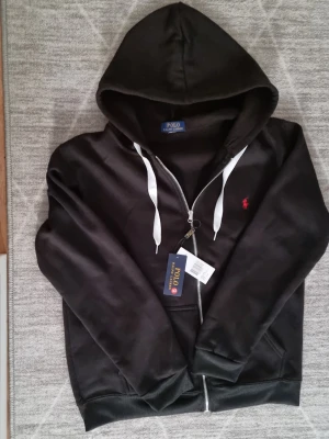 Svart hoodie från Polo Ralph Lauren - Snygg svart hoodie från Polo Ralph Lauren. Aldrig använts passar inte mig. 