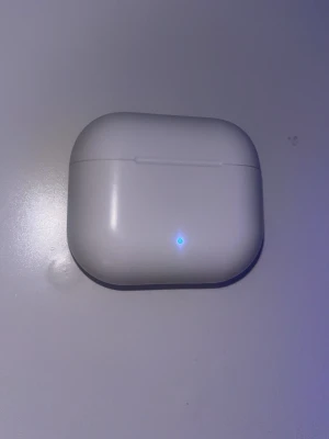 Vita trådlösa in-ear hörlurar - Säljer ett par vita trådlösa in-ear hörlurar med laddningsetui. Hörlurarna har en stilren och kompakt design med LED-indikator på etuiet. Perfekta för musik, poddar och samtal på språng. Laddas smidigt i det medföljande etuiet.