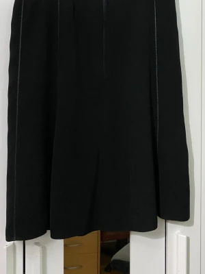 Svart skjol  - Köpte från secondhand länge sedan och har typ aldrig använt den. Storlek står inte men måtten är: midjan 41cm och längd är 65cm. Har inga skador eller fläckar alls.