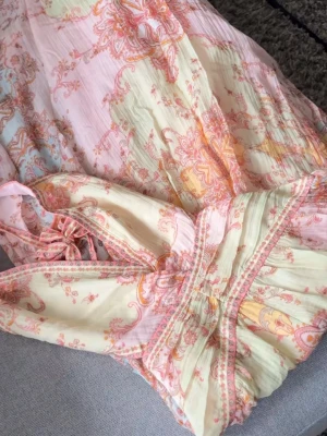 Lång boho-klänning i pastellmönster - Säljer denna superfina klänningen från H&M som är helt slutsåld på hemsidan! Romantisk långklänning i ljusa pastellfärger med blommigt mönster. Klänningen har omlottliv med v-ringning, smala axelband och markerad midja. Tillverkad i ett lätt, luftigt material som passar perfekt för varma dagar. Helt oanvänd, lapparna kvar!