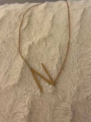 Guld halsband  - Ett guldigt halsband med bokstaven N i ett okej skick 