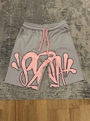 Gråa shorts med rosa design - Gråa shorts med rosa designer som är perfekt för kommande sommarn