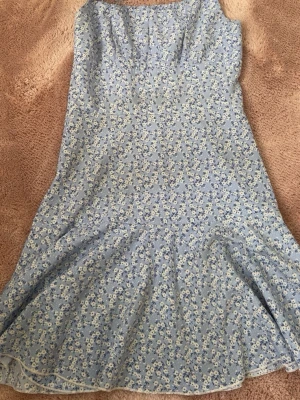 Blommig blå sommarklänning Shein - Söt blå klänning från Shein med smala axelband och blommigt mönster i vitt och blått. Klänningen har en lätt utsvängd form och är perfekt för varma dagar. Tillverkad i ett mjukt och lätt material.