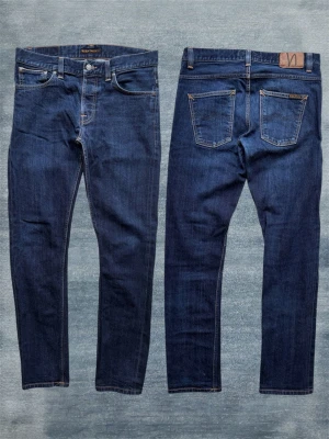 *SELVAGE* NUDIE GRIM TIM - Ett par extremt snygga selvedge jeans från nudie i den populära slimfit modellen ”Grim Tim”! Kommer att få ännu högre kontrast i sin fade vid mer användning! Storlek 32/34 - Hör av dig vid frågor!