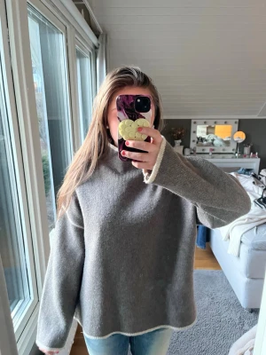 Intressekoll!!!!!!!! - Mysig grå stickad tröja i oversized modell med rund hals och kontrasterande vit kant vid ärmslut och nederkant. Perfekt för lager på lager och chill stil. Passar dig som gillar en avslappnad look. Skriv om ni är intresserade. Pris går att diskutera 