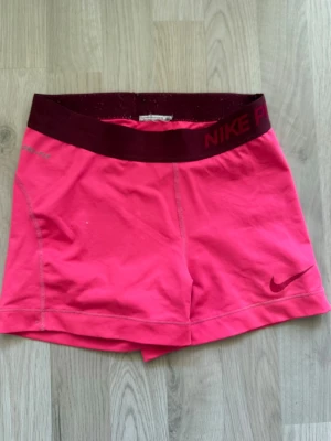 Rosa Nike Pro shorts med bred resår - Snygga rosa Nike Pro shorts med bred mörkröd resår i midjan, storlek xs💕