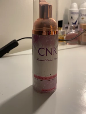 CNK Eyelash Foam Shampoo - Ett skonsamt ögonskum för rengöring av fransar från CNK. Kommer i en cylinderformad flaska med rosa och vita detaljer samt en praktisk pump. Perfekt för att hålla fransarna fräscha och rena.Den används inte bara för naturliga fransar utan man använder den för både lösögonfransar och när man har gjort sina fransar i en salong.Har använt den 2 ggr. 