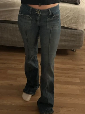 Blå bootcut jeans med stora fickor - Säljer ett par blå bootcut jeans med markerade sömmar och stora fickor både fram och bak. Använt fåtal gånger. 