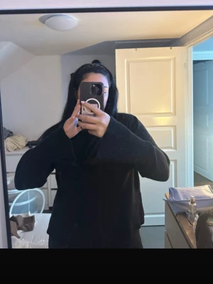 Svart stickad tröja från Bik Bok - En svart stickad tröja från Bik Bok med rund halsringning och långa ärmar. Tröjan har breda ribbade muddar vid ärmslut och nederkant, samt en något boxig och avslappnad passform. Perfekt för lager-på-lager och enkel att matcha.