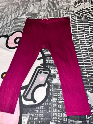 Vinröda leggings i stretchigt tyg - Säljer ett par vinröda leggings med enkel design och stretchigt material. De har en mjuk resår i midjan och är ankellånga. Perfekta att matcha med oversized tröjor eller hoodies för en chill look.