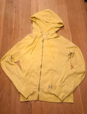 Gul Victoria’s Secret hoodie  - Snygg gul hoodie från Victoria secret. Tröja är använd några gånger så få stenar har låsnat från ryggen men inget som märks. Storlek xs-s.