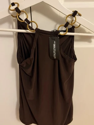 Brun linnetopp med guldringar PLT - Snygg brun linnetopp från PrettyLittleThing storlek 34 XS-S oanvänd men prislapp på 