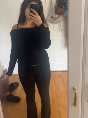 Svart offshoulder bolerotopp - Säljer en svart offshoulder topp med lång ärm och croppad passform. Passar dig som vill ha en trendig och bekväm topp.