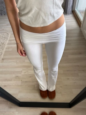 Vita bootcut leggings med låg midja - Säljer ett par vita leggings med bootcut och låg midja. Dem är i största storleken i barn men sitter som en xs 💕