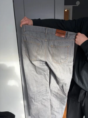 Grå jeans från Montén 30/30 - Snygga grå jeans från Montén i klassisk femficksmodell. Jeansen har raka ben, ljus tvätt och kontrastsömmar. Tillverkade i ett mjukt denimtyg som passar perfekt till en avslappnad stil. Märkespatch bak i midjan för extra detalj.