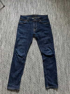 Nudie Jeans - Mörkblåa Nudie jeans med vit brodyr. Modell Thin Finn 30/30. Inga defekter. 