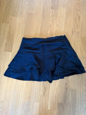 Svart lågmidjad kjol, inbyggda shorts! - Svart lågmidjad volangkjol med tjockt midjeband. Den har även inbyggda shorts😍 Köpt på Zara i London. Aldrig använt då den inte passar så som jag hade velat.💗