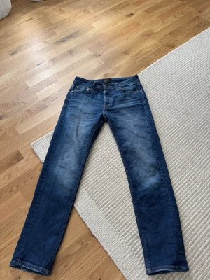Mörkblå jeans från Jack & Jones  - Snygga mörkblåa jeans från Jack & Jones i storlek 28/30. Sitter slim/straight i passformen.