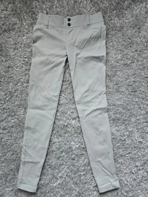 Grå leggings från ICANIWILL XS - Snygga grå leggings från ICANIWILL i storlek XS. De har hög midja med dubbla knappar och smickrande sömmar längs benen. Materialet är stretchigt och bekvämt, perfekt för en aktiv livsstil eller chill dagar. Endast provade en gång.  