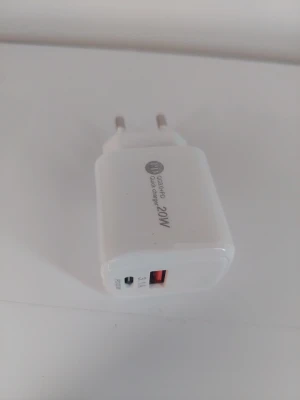 Vit 20W snabbladdare USB & USB-C - Vit snabbladdare med 20W effekt, utrustad med både USB-A och USB-C port. Perfekt för att ladda mobiltelefoner och andra enheter snabbt. Kompakt och smidig design i plast, passar i vägguttag med europeisk kontakt.