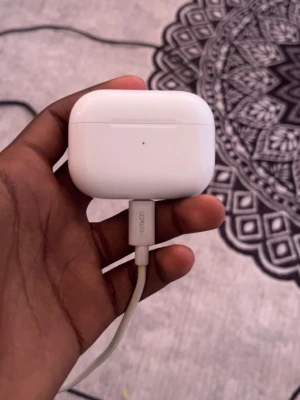 Vita trådlösa hörlurar med laddningsetui. AirPods - Säljer ett par vita Apple AirPods Pro med laddningsetui. Hörlurarna har en stilren och kompakt design i blank plast och levereras med ett matchande vitt laddningsfodral. Perfekta för musik, samtal och träning tack vare sin smidiga form och trådlösa funktion.