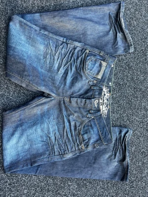 Blå jeans med slitningar och detaljer - Snygga Swag jeans! Sitter baggy! Osäker om storlek (S-M), hänvisar till måtten på bilderna! 