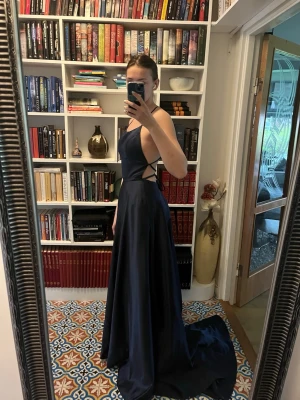 Marinblå långklänning med slits - Säljer min fina balklänning från nian, endast använd en gång och är i perfekt skick! Den har ett fint släp på baksidan och passar mig som är 176cm lång! Klänningen har två rymliga fickor på vardera sida som inte syns och passar perfekt för att ha mobil eller plånbok i💕 Storleken finns ej på klänningen och jag kommer inte ihåg exakt, men gissar på S. Skriv om du vill veta mer specifika mått så kan jag ta reda på det!🥰