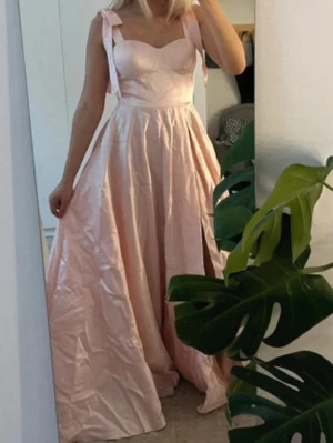Rosa balklänning  - Säljer så fin balklänning som aldrig använts, jättesöta rosetter på sidorna. Jag har inte strykt den därav är den skrynklig.