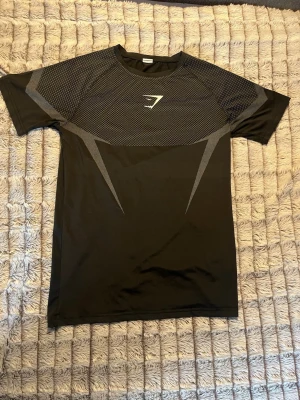 Gymshark compression shirt - En svart/grå/ vit Gymshark onyx comperssion shirt. Den är i otroligt bra skick och är gjord i bra stretchigt material. 