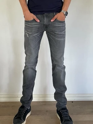 Replay Jeans - Säljer ett par riktigt fräscha svart/grå Replay Jeans med slitningar för endast 399kr!              Använd ett fåtal gånger                                                                       Nypris:1799kr därav väldigt bra erbjudande.             Modell: anbass - slim fit                                                       Om ni har några frågor är det bara att fråga på!