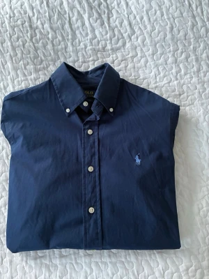 Polo Ralph Lauren Skjorta - Säljer denna Polo Ralph Lauren skjorta i färgen marinblå. Passformen är slim och storlek XS. Skjortan är perfekt nu inför sommar och hör av er vid minsta fundering eller nån fråga😃🤝