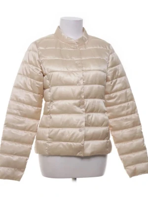 Beige pufferjacka - Snygg beige pufferjacka med knäppning framtill. Jackan har en quiltad design med horisontella sömmar och är tillverkad i ett glansigt material. 