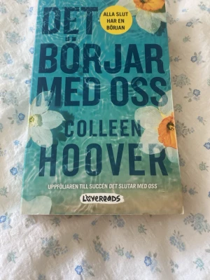 Det börjar med oss av Colleen Hoover - En pocketbok med blågrönt omslag och blommor, skriven av Colleen Hoover. Boken är en uppföljare till 'Det slutar med oss' och handlar om kärlek och relationer. Perfekt för dig som gillar gripande och känslosam skönlitteratur. På svenska! 