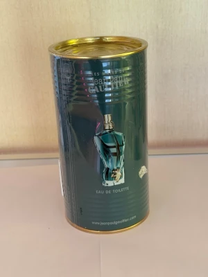 Jean Paul Gaultier Le Male parfym - Jean Paul Gaultier Le Male Eau de Toilette i sin ikoniska gröna metallburk med guldiga detaljer. Förpackningen har en bild av den klassiska blå flaskan formad som en manlig torso. Perfekt för dig som gillar unika och snygga designer.