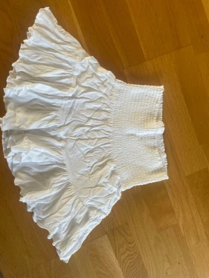Vit volangkjol från 157, storlek S - Skriv innan köp!🥰Supersöt vit kortkjol från 157 med bred smock i midjan och volangig nederdel. Kjolen är lätt och luftig, perfekt för varma dagar. Enkel att matcha med både toppar och sneakers för en chill look.